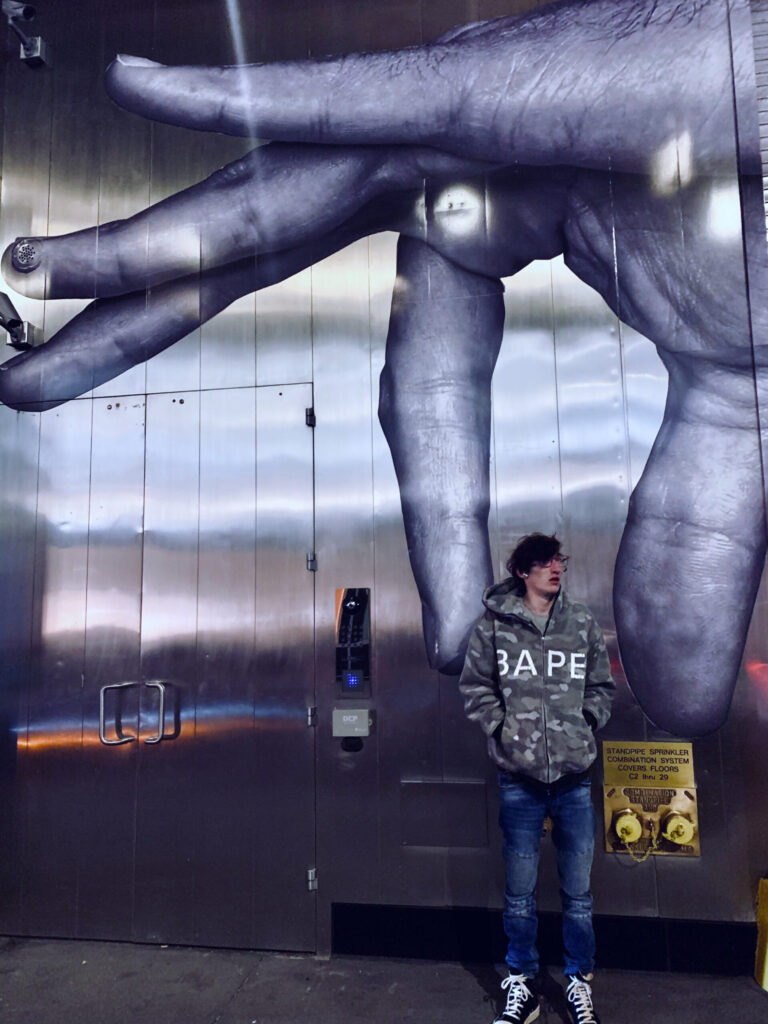 Max Allen standing in front of a mural in NYC